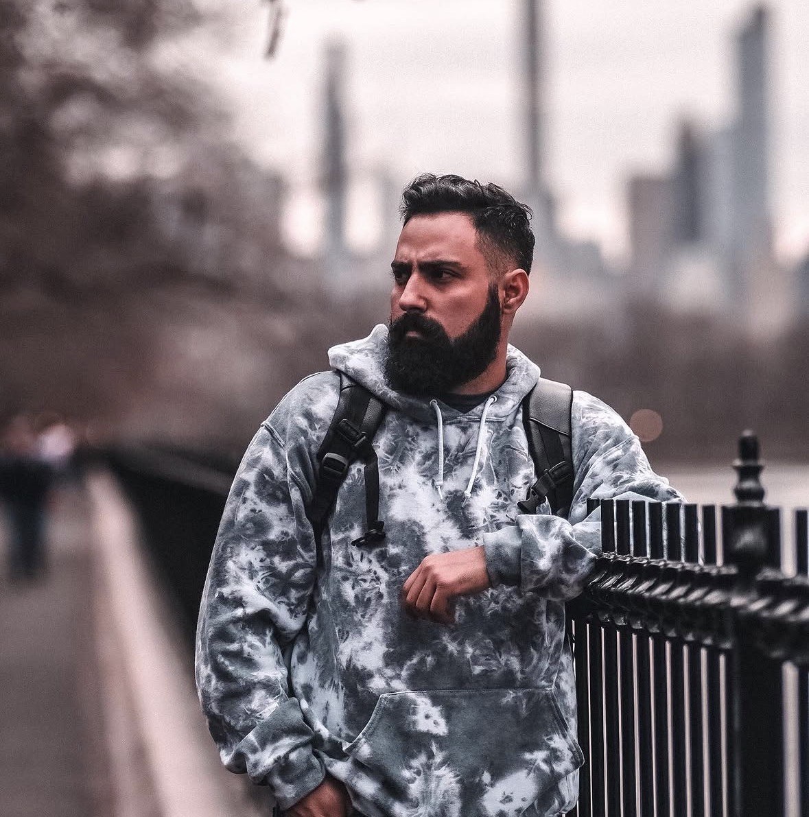 Eduardo Dantas leaning on an iron railing, with the Manhattan skyline behind him
