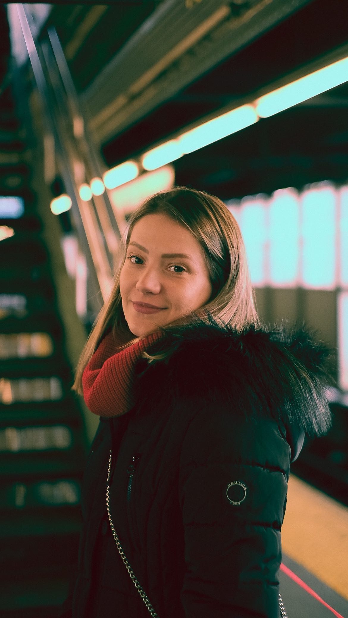 Portrait of a woman on a subway platform, looking into the camera