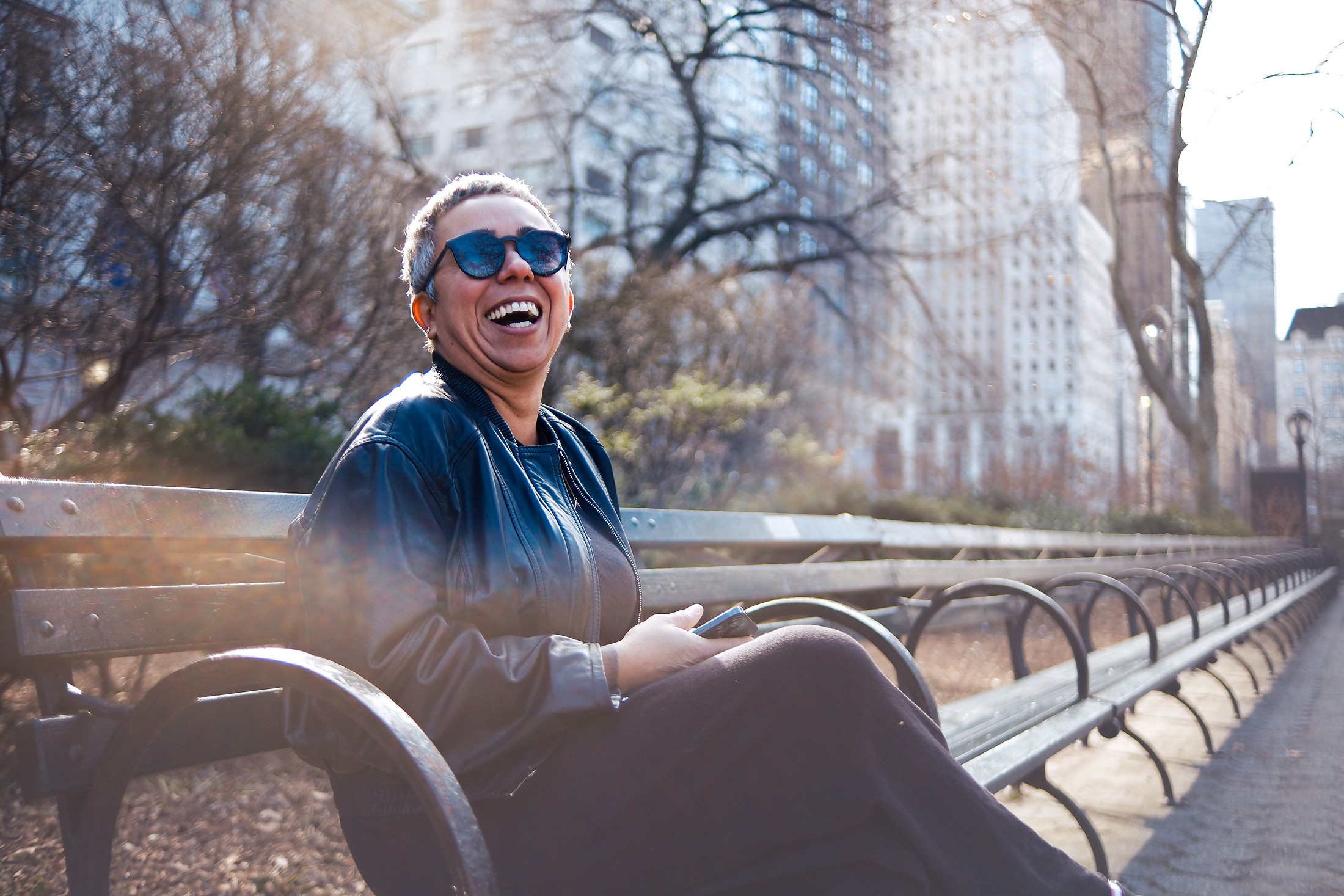 Woman laughing on a park bench on an autumn afternoon