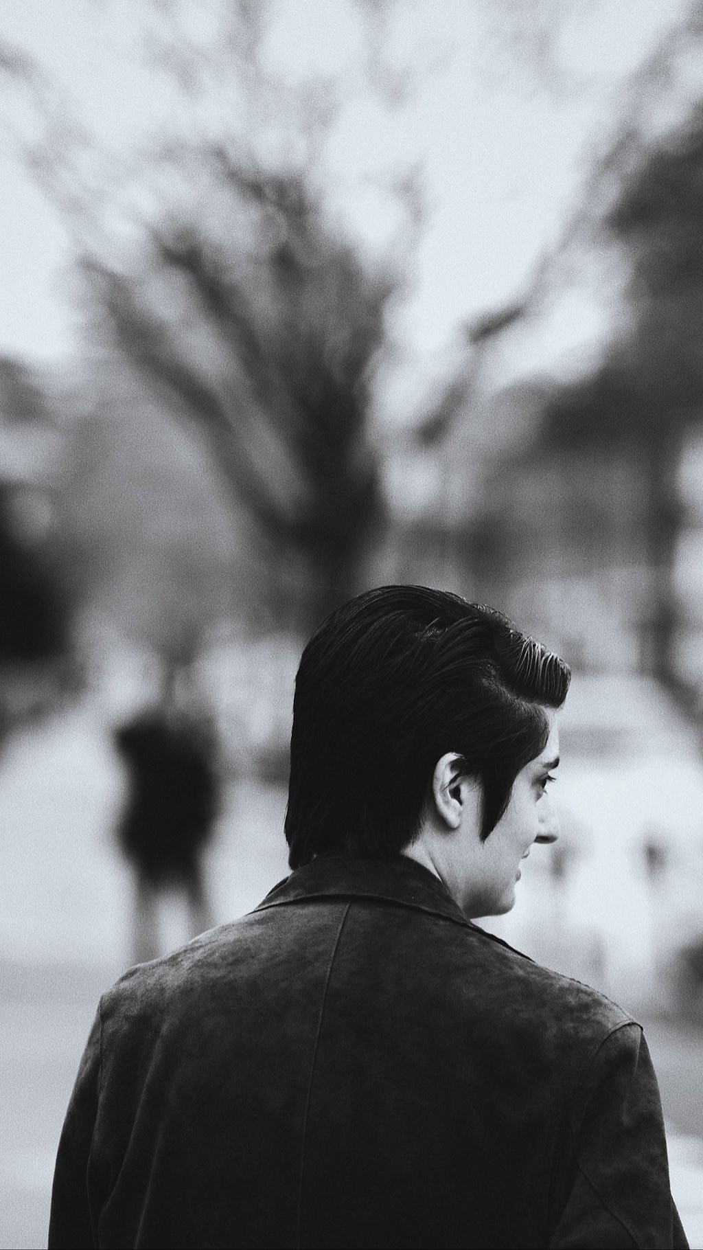 Black and white portrait of a man from behind, looking to the side
