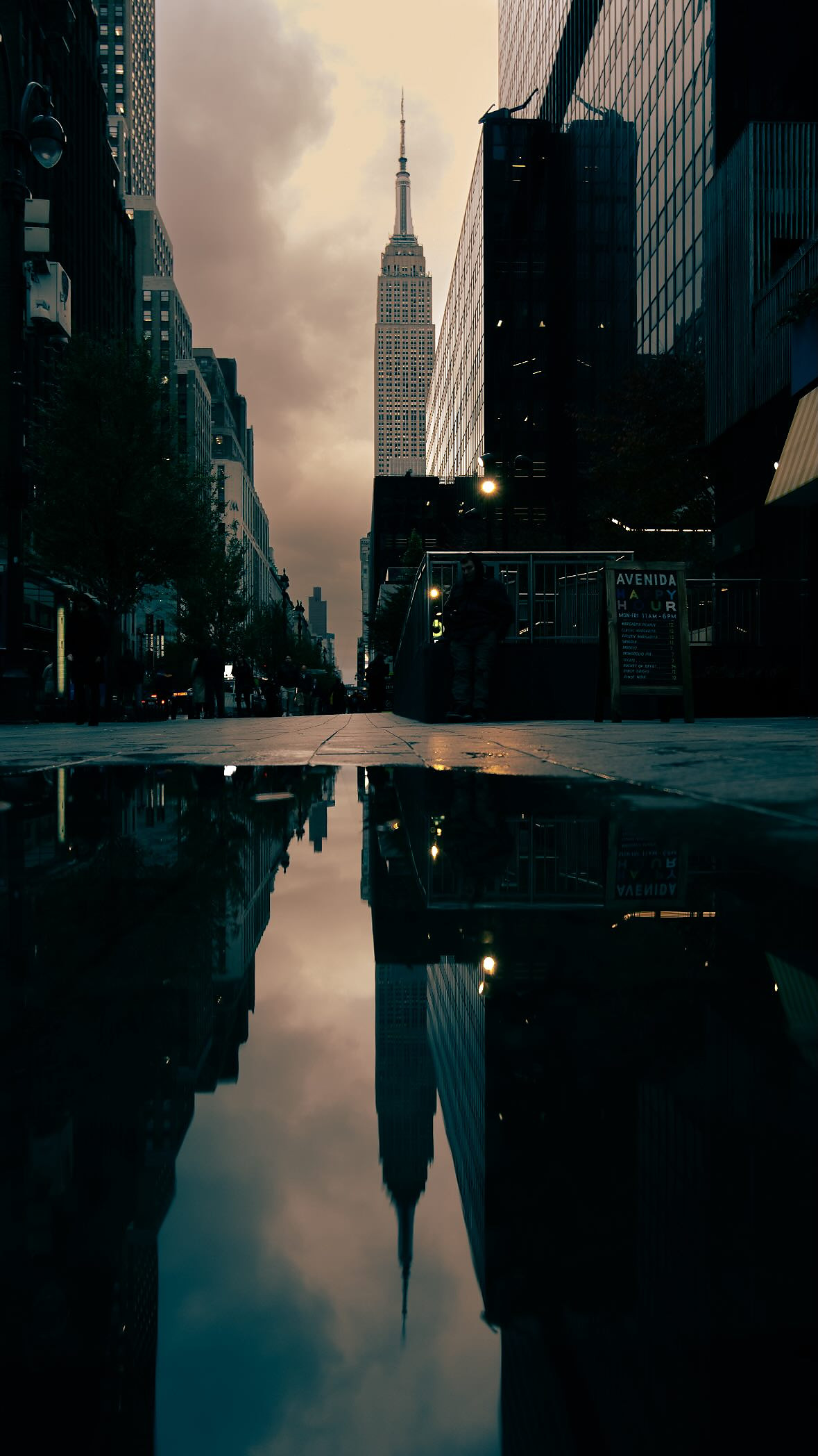 The Empire State Building mirrored in a puddle after rain